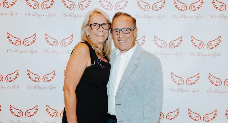 two people embracing in front of a photo backdrop