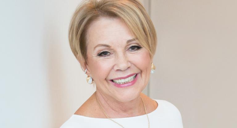 Woman wearing white, smiling at camera