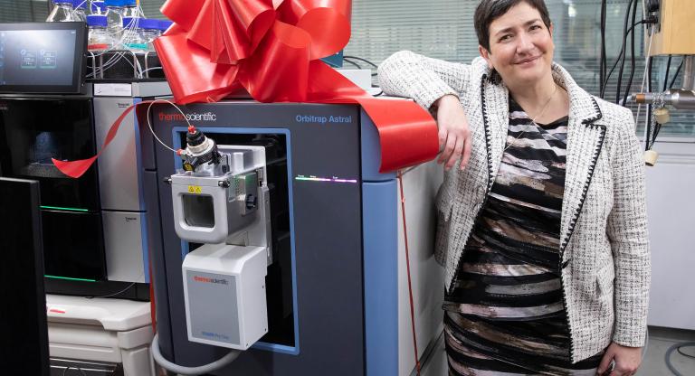 Dr. Anne-Claude Gingras stands next to the Astral mass-spectrometer