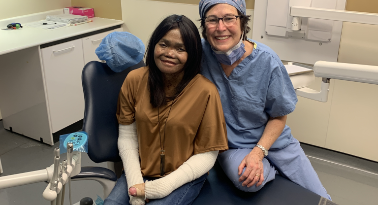 doctor and patient sit together on dentist chair