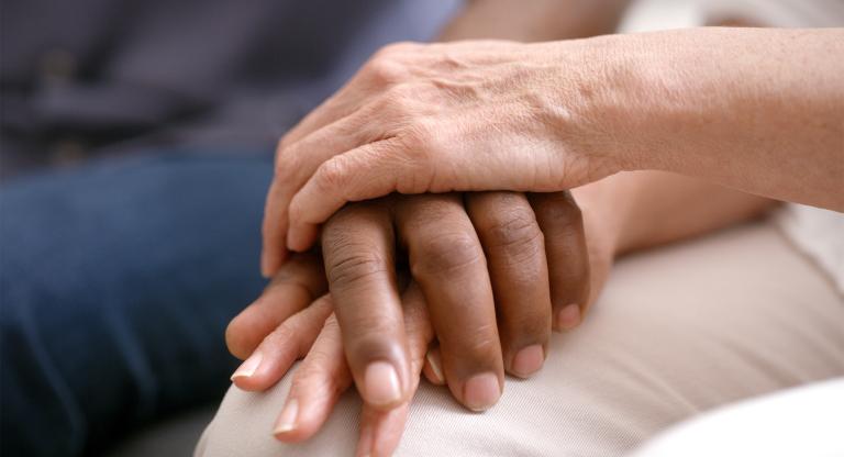 Close up on two people holding hands