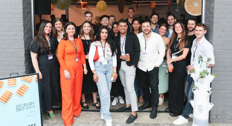 Group photo of young people by grey walls