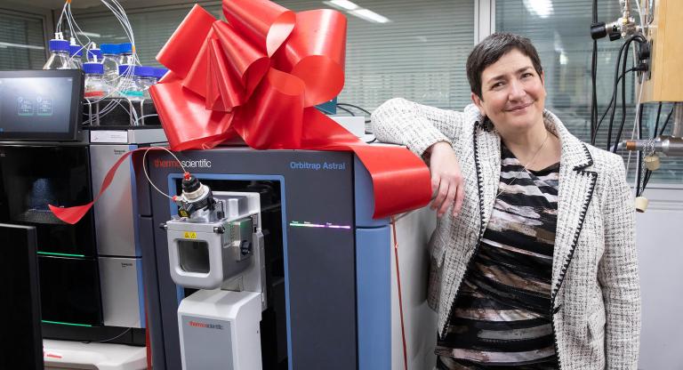 Person leaning on brand new medical equipment with a red bow on top