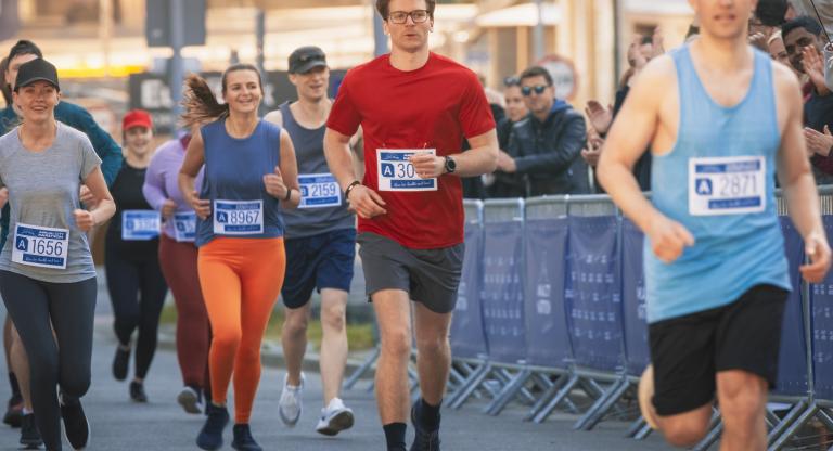 People running a marathon on a city street