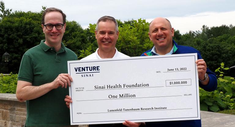 Three men holding a giant cheque